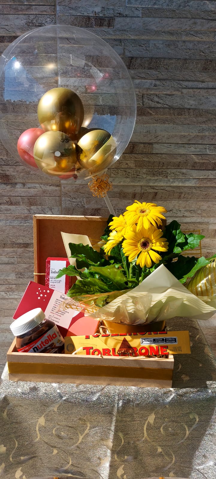 cesta para presentear, com girassol, torrone e muitas coisas gostosas de comer